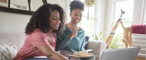 Mother and daughter working with their laptop